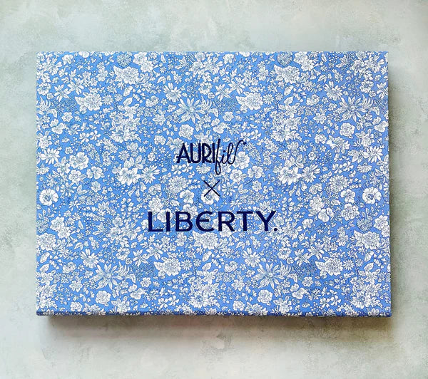 Aurifil X Liberty is a luxurious 45-spool thread collection that unites Aurifil's renowned Italian craftsmanship with Liberty's iconic British design heritage. Presented in a Liberty fabric-wrapped collector's box featuring the beloved Emily Belle florals in Marine Blue, this collaboration shines a spotlight in one of Liberty's most cherished prints.

Inside, 45 small spools of Aurifil's 100% Cotton 50wt thread have been meticulously curated to echo Liberty's timeless palette. Perfect for quilting, garment 