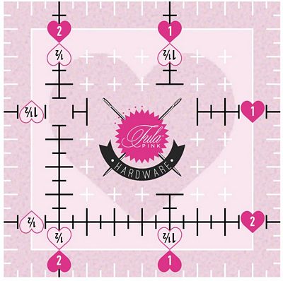 Tula Pink 2.5in x 2.5in Heart Cutting Ruler is a US made ruler that features: nonslip coating, fuzzy cut and angle markings, 1/4in margins all around, two color markings with fine marking lines for accurate cutting, and clear center squares for accuracy.