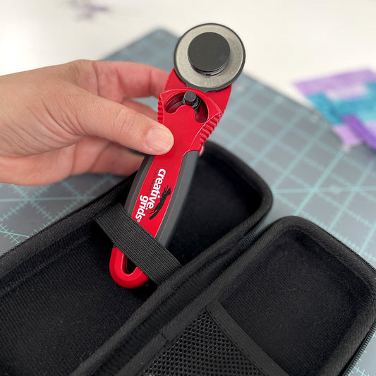 The Creative Grids® 45mm rotary cutter is designed with you in mind. The sleek red metal body adds weight to the cutter so less pressure is required when cutting fabric. The cushioned, comfort grip is designed to fit your hand, reducing slips and muscle fatigue.  When the button is in the center, the guard fully protects the blade when not in use. Move the button a quarter circle to the left or right to expose the blade for right and left handed users. 