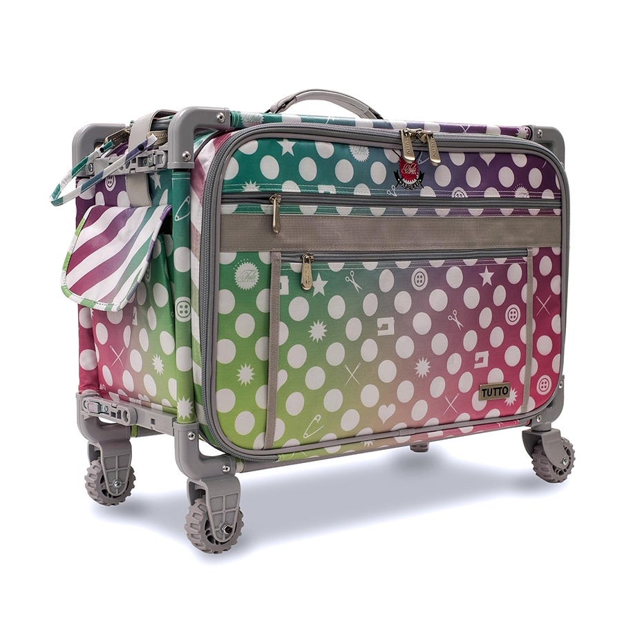 Exclusive Tula Pink innovative transportation system from Tutto.  On the exterior, the Tula Pink signature rainbow shimmer print coordinates with Tula's 570 QE Bernina sewing machine.  Manufactured from balistic nylon and features a fiberglass frame, two inside straps for security & mesh pockets for storage.   23"L x 14.25"H x 14"D.  Folds to 3in for storage.  Top access 19"L x 10"D or side load. Stacks up to 150 lbs and weighs only 11 lbs empty. Fits all 7 Series Bernina Machines.